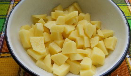 картофель с куриными крылышками и баклажанами на сковороде