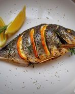 Дорада, запеченная с лимоном, чесноком и травами