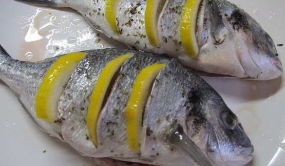 дорада, запеченная с лимоном, чесноком и травами