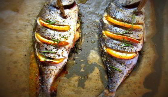 дорада, запеченная с лимоном, чесноком и травами