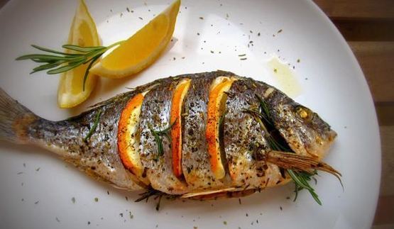 дорада, запеченная с лимоном, чесноком и травами
