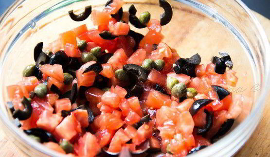 сибас, запеченный с томатами, оливками и каперсами