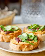 Кростини с хумусом, базиликом и оливками